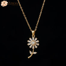 Gold necklace with a flower-shaped pendant on a black background, branded 'ZZILYA'.