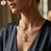 Close-up of a person wearing a gold necklace with a pineapple pendant, brand 'ZZILYA' visible.