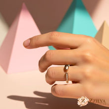 Minimalist rose gold open-wrap ring on a finger featuring a shimmering pavé crystal bar on one end and a polished gold sphere on the other.