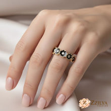 Close-up of a gold black flower enamel ring, an ideal adjustable-size gift for her, packaged for spring and summer fashion collections.