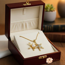 Gold necklace with starfish and pearl pendant in an open wooden jewelry box by ZZilya