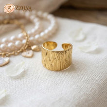 Gold ring on a textured white surface with 'Zzilya Fashion' branding.