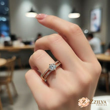 Close-up of a hand wearing a Zzilya rose gold solitaire ring with a large round-cut center stone and a double-row pavé crystal split-shank band.