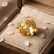 Gold leaf ring on a soft surface with 'Zzilya' branding.