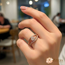 Close-up of a hand wearing a Zzilya anti-tarnish rose gold ring featuring a central crystal flower and two curved pavé bands in a modern wave design.