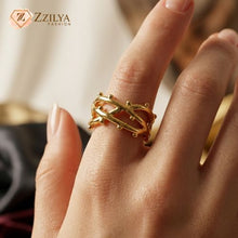 Gold ring on a finger with Zzilya Fashion logo in the corner