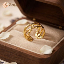 A close-up view of a person's hand wearing a unique, organic-style gold ring on the index finger. The ring is a twisted, abstract band with multiple small, raised, bead-like 'thorns' distributed across its surface by Zzilya fashion