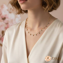 A woman wearing a ZZILYA Fashion dainty gold station necklace featuring multiple small, round clear crystals hanging at regular intervals along the chain.