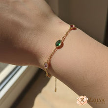 Dainty gold link bracelet featuring marquise-cut green, pink, and red gemstones on a woman's wrist by Zzilya fashion