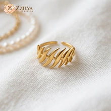 ZZILYA Fashion adjustable golden ring with a bold multi-claw sculptural design on a white textured fabric background.