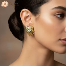 Close-up of a woman wearing gold textured fan-shaped statement earrings from Zzilya Fashion, featuring a bold architectural swirl design and vintage-inspired gold finish.