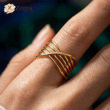 Gold ring on a finger with Zzilya Fashion logo in the corner