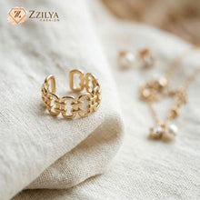 Gold chain ring on a textured beige surface with 'Zzilya Fashion' branding.