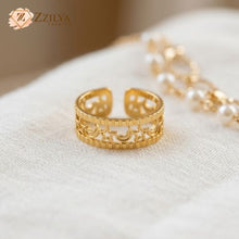 Gold ring with intricate design on a white fabric background, featuring the brand 'ZZILYA'.