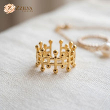 Gold ring with a geometric design on a textured surface, branded 'ZZILYA'.