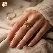 A person wearing the ZZILYA Fashion golden lattice ring with a crown-like geometric design on their index finger, paired with neutral linen clothing.