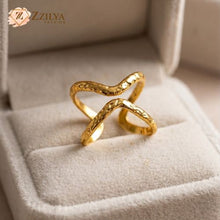 Gold ring with a textured design on a soft surface, branded 'ZZILYA'.