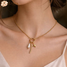 Gold necklace with star and pearl pendant worn by a person by zzilya fashion