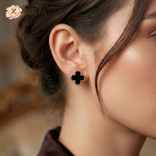 Close-up of a woman wearing a black clover-shaped earring with a blurred background by zzilya Fashion