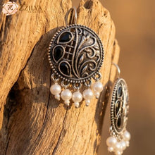 oxidized silver earrings with pearl drops on a wooden surface by zzilya fashion under rs 99