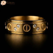 Gold ring with diamond accents on a dark background, branded 'ZZILYA'.