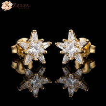 Star-shaped gold and diamond earrings on a black background with 'ZZILYA' branding.