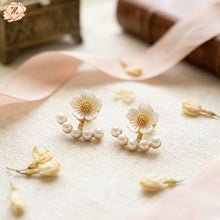 A delicate white flower stud featuring a shimmering golden center, paired with a trendy curved arc of pearls that hugs the earlobe under Rs 99 by zzilya fashion