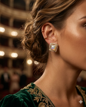 Pair of square-shaped gold stud earrings featuring a raised mother-of-pearl center and a geometric pavé crystal border by Zzilya Fashion.