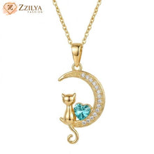 Gold necklace with a cat and heart design pendant on a white background, branded 'ZZILYA'.