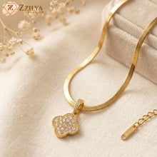 Gold necklace with a diamond pendant on a beige fabric background, featuring the brand 'Zzliya'.