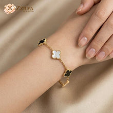 Gold bracelet with floral designs on a wrist, branded 'ZZILYA'.