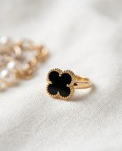 Gold ring with black clover design on a white fabric background by Zzilya fashion Jewellery