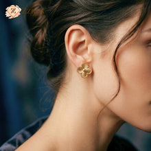 Close-up of a woman wearing a golden Clover earring by zzilya fashion