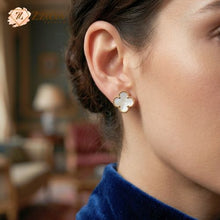Close-up of a person wearing a white Clover earring by zzilya fashion
