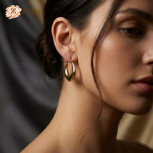 A pair of gold-toned hoop earrings with a unique, organic undulating shape  by ZZILYA Fashion.