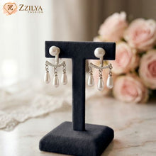 Pearl earrings on a black stand by zzilya fashion under Rs 99