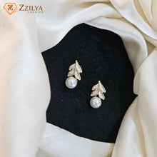 Korean gold leaf enamel stud earrings with white pearl drop on black fabric background under 99