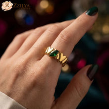 emerald Gold ring with a green gemstone on a blurred background by zzilya fashion