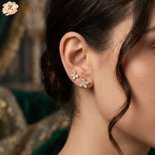 Close-up of a woman wearing butterfly earrings with a blurred by zzilya fashion background