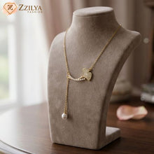 Gold necklace with a pearl shaped pendant on a mannequin bust, branded 'Zzilya Fashion'.