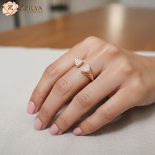 Hand wearing diamond ring on a neutral background with 'ZZILYA' branding.