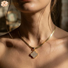 Gold necklace with a diamond pendant worn by a person, brand 'Zzilya' visible.