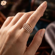 Rose gold ring with diamonds on a hand, brand 'ZZILYA' visible