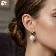 Pearl earring worn by a person with a blurred background by zzilya fashion