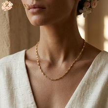 A woman wearing a ZZILYA Fashion gold twisted rope neckchain against a white linen top, highlighting its elegant anti-tarnish finish.