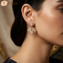 Model wearing ZZILYA Fashion golden anti-tarnish drop earrings with pear-cut crystals and floral gold filigree, styled as professional office jewelry.
