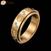 A high-polish golden anti-tarnish band ring by Zzilya Fashion with engraved screw-head motifs and pairs of small clear cubic zirconia stones, set against a solid black background.