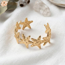 Gold star-shaped bracelet on a white fabric background