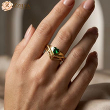 A golden anti-tarnish adjustable ring set by Zzilya Fashion featuring a central heart-shaped emerald zircon and textured chevron bands, worn on a model's hand against a neutral background.