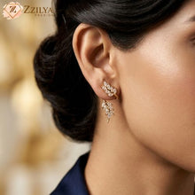 Close-up of a woman wearing gold earrings with a blurred background and 'ZZILYA' branding.